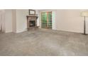 Spacious living room with a stone fireplace, sliding glass doors and plush carpeting at 6505 Kalua Rd # 104B, Boulder, CO 80301