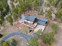Beautiful house featuring multiple decks, surrounded by dense trees and including a driveway and lush landscaping at 13660 Rampart Dr, Conifer, CO 80433