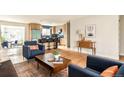 Open-concept living room with hardwood floors, modern furnishings, and a view into the kitchen at 815 S Jersey St, Denver, CO 80224