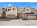 Townhome exterior featuring tan siding, stone accents, manicured landscape and attached garages at 12214 Stone Timber Ct, Parker, CO 80134