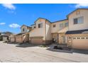 Exterior of townhome with tan siding, stone accents, attached garages and manicured landscaping at 12214 Stone Timber Ct, Parker, CO 80134