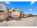 Exterior of townhome with tan siding, stone accents, attached garages and manicured landscaping at 12214 Stone Timber Ct, Parker, CO 80134