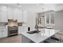Bright kitchen with white cabinets, stainless steel appliances, and an adjacent dining area at 12214 Stone Timber Ct, Parker, CO 80134