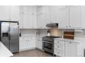 Bright kitchen features white cabinets, stainless steel appliances, and granite countertops at 12214 Stone Timber Ct, Parker, CO 80134