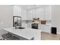 Modern kitchen with white cabinets, stainless steel appliances, and a center island with seating at 12214 Stone Timber Ct, Parker, CO 80134