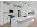 This bright kitchen features an island with stone countertops and stainless steel appliances at 10860 Lyric St, Lone Tree, CO 80134