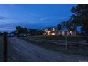 House exterior view at dusk with driveway and wooden fence at 12626 N 1St St, Parker, CO 80134