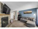 Comfortable living room features a stone fireplace, blue accent wall and gray sectional sofa at 3253 S Estes St, Lakewood, CO 80227
