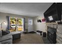 Inviting living room boasts a stone fireplace, large window, and cozy seating area at 3253 S Estes St, Lakewood, CO 80227