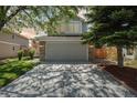 Charming home exterior with a wide driveway, stone accents, and a well-maintained lawn at 1462 Marigold Dr, Lafayette, CO 80026