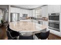 Bright kitchen featuring granite countertops, stainless steel appliances, and modern white cabinets at 17077 E 111Th Ave, Commerce City, CO 80022