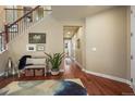 Inviting foyer with hardwood floors and an open staircase, adjacent to a bench and decor at 14284 Double Dutch Cir, Parker, CO 80134