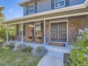 Inviting front porch with rocking chairs, brick facade, and well-maintained landscaping at 4196 S Reading Way, Denver, CO 80237