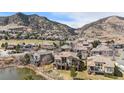 Picturesque aerial shot showcases this home's premium lot near a tranquil pond and beautiful mountain views at 16323 River Haven Way, Morrison, CO 80465