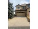 Inviting front exterior featuring a two-car garage, well-maintained lawn, and ample driveway space at 16323 River Haven Way, Morrison, CO 80465