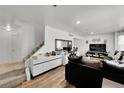 Bright living room featuring hardwood floors, comfortable seating, and a staircase at 4848 S Pitkin Way, Aurora, CO 80015