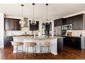Open kitchen with dark cabinets, stainless appliances, granite countertops, and a spacious island with bar seating at 27274 E Lakeview Pl, Aurora, CO 80016
