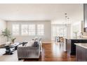 Bright, open-concept living space with hardwood floors, lots of windows, and seamless kitchen access at 27274 E Lakeview Pl, Aurora, CO 80016