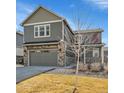 Charming two-story home featuring a stone facade, gray siding, covered porch, and a two-car garage at 20040 E 61St Dr, Aurora, CO 80019