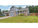 Charming two-story home with a brick and siding exterior, a well-manicured lawn and an attached two-car garage at 6017 S Pierson St, Littleton, CO 80127