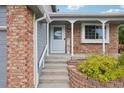 Inviting front porch with brick accents, decorative columns, and a welcoming entrance at 6017 S Pierson St, Littleton, CO 80127