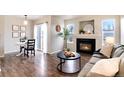 Bright living room features a fireplace, wood floors, dining table, and sliding door access to the exterior at 18397 E Alabama Pl # D, Aurora, CO 80017