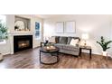Inviting living room featuring a cozy fireplace, gray sofa, modern decor, and stylish dark wood-look flooring at 18397 E Alabama Pl # D, Aurora, CO 80017