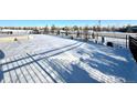 Snowy backyard with a fence and a glimpse of a pool at 15454 W Auburn Ave, Lakewood, CO 80228