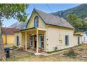 Quaint two-story home with yellow siding and mountain views on a sunny day at 400 Argentine St, Georgetown, CO 80444