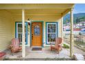 Inviting front porch with wood chairs and a decorative front door at 400 Argentine St, Georgetown, CO 80444