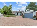 Charming blue home featuring a detached garage, nice landscaping, and great curb appeal at 247 Tipple Pkwy, Frederick, CO 80530