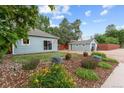 Landscaped front yard featuring a lawn, trees, flower beds, and a home with a detached garage at 247 Tipple Pkwy, Frederick, CO 80530
