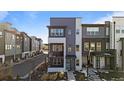 Modern townhome featuring multi-tone color scheme, balcony, and tidy landscaping at 1415 W 68Th Ave, Denver, CO 80221