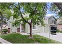Two-story home with an attached two car garage, neutral exterior and a lovely front yard and mature tree at 8997 W 88Th Ave, Westminster, CO 80021