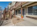 Ground floor entrance of unit, showcasing wooden stairs and stone details at 1885 S Quebec Way # A16, Denver, CO 80231