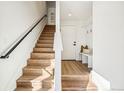 Bright entryway features a staircase with black metal handrail, wood flooring, and a convenient built-in bench at 1412 Pierce St, Lakewood, CO 80214