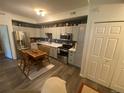 Eat-in kitchen with stainless appliances, light cabinets, and wood-look floors at 7170 S Wenatchee Way # C, Aurora, CO 80016