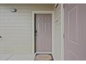 Neutral-colored front door with security features and a welcome mat on a light wood siding building at 12896 Ironstone Way # 203, Parker, CO 80134