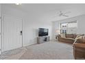 Bright living room with neutral carpet, ceiling fan, large window, and a comfortable sofa at 12896 Ironstone Way # 203, Parker, CO 80134