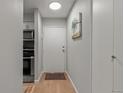 This entryway has gray walls, a white entry door, a small area rug, and wood-look floors at 7455 E Quincy Ave # 204, Denver, CO 80237