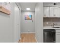 This hallway features wood-look floors, modern art, and a doorway to the kitchen space at 7455 E Quincy Ave # 204, Denver, CO 80237