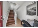 Welcoming entryway with a staircase, tiled floor, and stylish bench with artwork at 13023 Grant Cir # C, Thornton, CO 80241