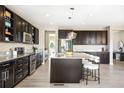 Kitchen with stainless steel appliances, dark cabinets, large island, granite countertops, and pendant lighting at 11100 Pastel Pt, Parker, CO 80134
