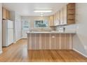 Bright kitchen featuring wood-look island, white appliances, wood cabinets, and lots of natural light at 3006 W 107Th Pl # D, Westminster, CO 80031