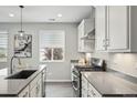 Well-lit kitchen featuring stainless steel appliances, white cabinetry, and a large island with bar seating at 1592 Maggie Mae Ln, Castle Rock, CO 80104
