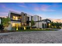 Elegant modern home with illuminated landscaping and a dramatic sunset backdrop, showcasing architectural design at 2821 E Cedar Ave # 17, Denver, CO 80209
