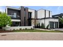 Modern architectural design showcases a two-car garage, black trim and white exterior, plus landscaped front yard at 2821 E Cedar Ave # 17, Denver, CO 80209