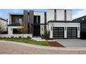 Striking modern home featuring a two-car garage, contrasting black and white facade, and minimalist landscaping at 2821 E Cedar Ave # 17, Denver, CO 80209