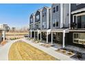 Row of modern townhomes featuring brick facade with lawn and common space at 888 S Valentia St # 14-103, Denver, CO 80247