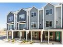 Row of modern townhomes featuring brick facade and covered porches at 888 S Valentia St # 14-103, Denver, CO 80247